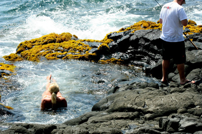 Lucky fisherman got the catch of the day, but if he isn't careful, a big wave might wash it away. Catch of the Day